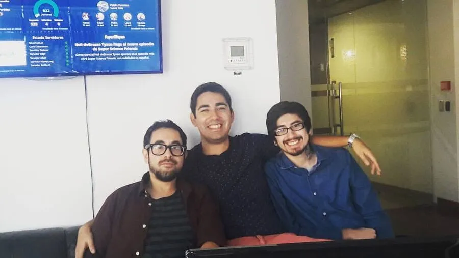 Tres integrantes del equipo de Silverhost sentados en la oficina, con un panel de monitoreo en la pantalla