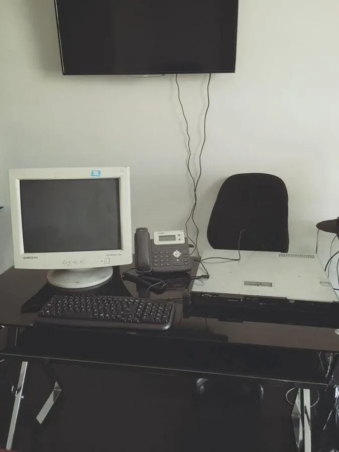 Escritorio de la oficina con un monitor antiguo, un teclado y un teléfono